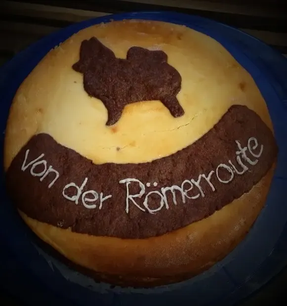 Runder Kuchen mit einem Wolfsspitz aus Schokolade und der Aufschrift Von der Römerroute
